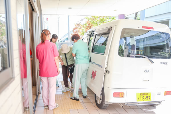 送迎車から利用者を降ろすスタッフ