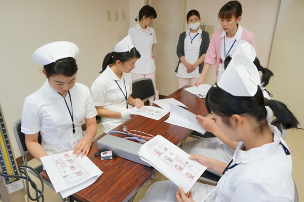 医療機器の操作手順を確認する看護学生